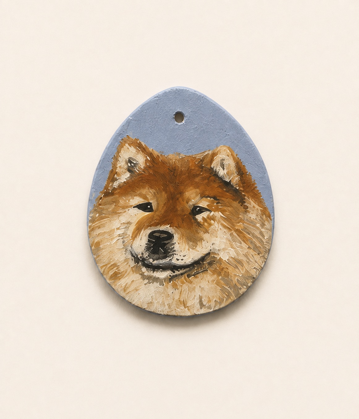 Acrylic portrait of a rust-colored Chow Chow on an egg-shaped clay pendant